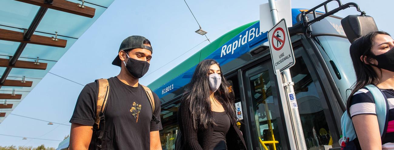 Students walking by translink bus